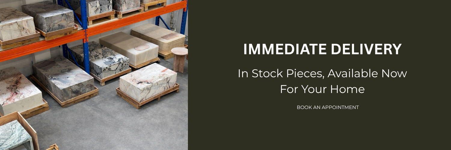 Natural Stone Co immediate delivery banner showing in-stock marble and natural stone pieces stored on warehouse pallets.